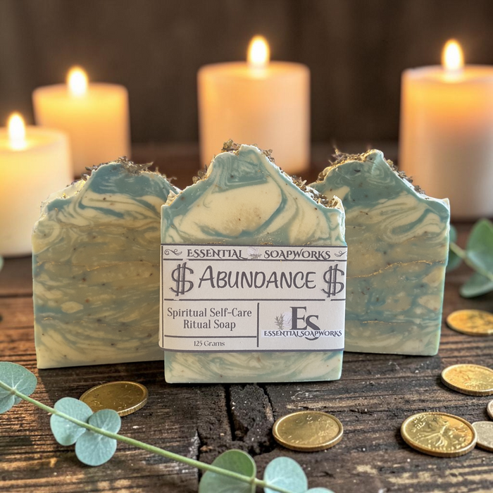abundance soap on a wooden surface with gold coins and candles in the background