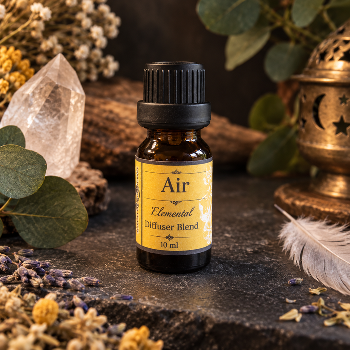 Air elemental essential oil diffuser blend in a 10 ml amber bottle styled with airy botanicals and ritual decor.