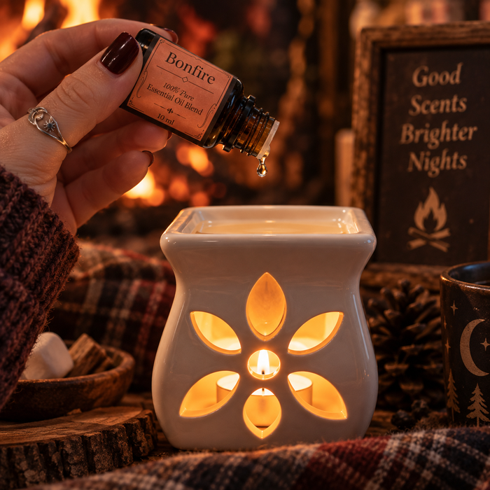 Bonfire witchy diffuser blend being poured into an essential oil burner on a brown fabric surface
