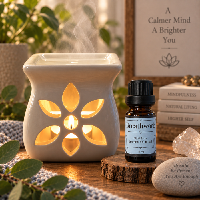 Breathwork essential oil diffuser blend on a wooden surface alongside an essential oil burner with crystals and stacked books
