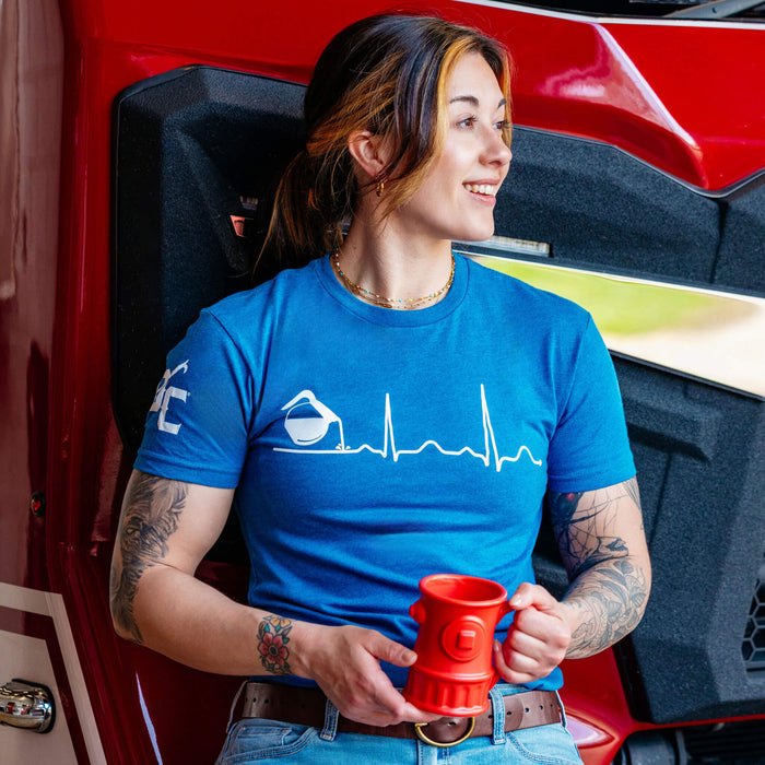 A woman wearing the blue Coffee EKG shirt holding a red coffee mug.