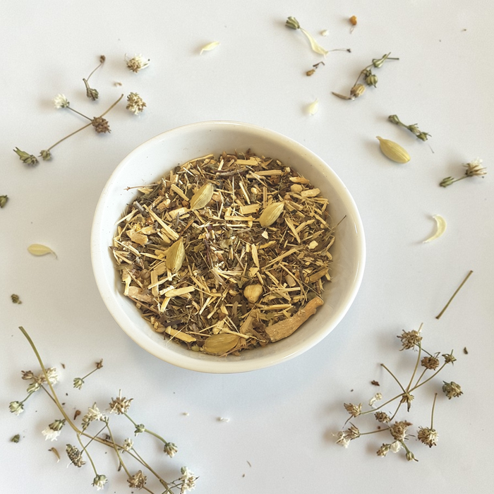 Courage emotional wellness tea blend on a light background with scattered herbs.