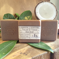 coconut tallow soap bars on a wooden surface with  a slice of coconut