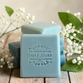 cypress tallow soap on a wooden surface with white flowers