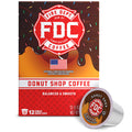 A box of FDC Fire Department Coffee Donut Shop Coffee with a single single-serve coffee pod placed in front on a white background.