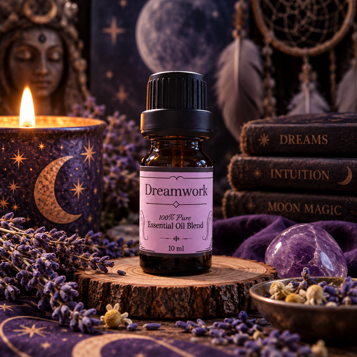 Dreamwork witchy diffuser blend on a wooden surface with lavender and amethyst crystals and a candle and stacked books in the background