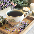 energy cleanse herbal tea on a wooden tray with lavender and candles in the background