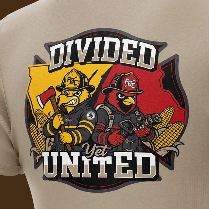 Close-up of a beige T-shirt showing a large front graphic with two cartoon fire fighters and the words “DIVIDED Yet UNITED.”