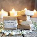 Gentle Surrender Emotional Wellness Soap on a doily on a wooden surface with candles in the background