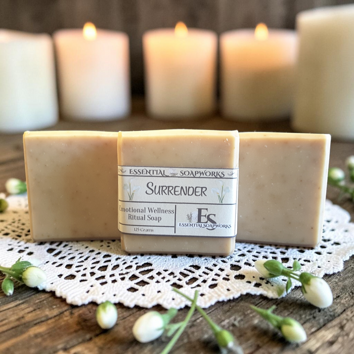 Gentle Surrender Emotional Wellness Soap on a doily on a wooden surface with candles in the background