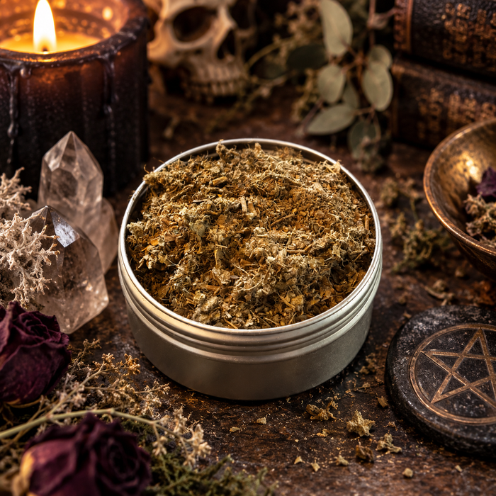 graveyard dirt on a dark surface with botanicals, crystals and candles