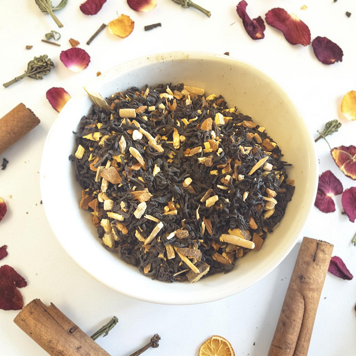 Grounding loose leaf tea blend in a bowl on a white background