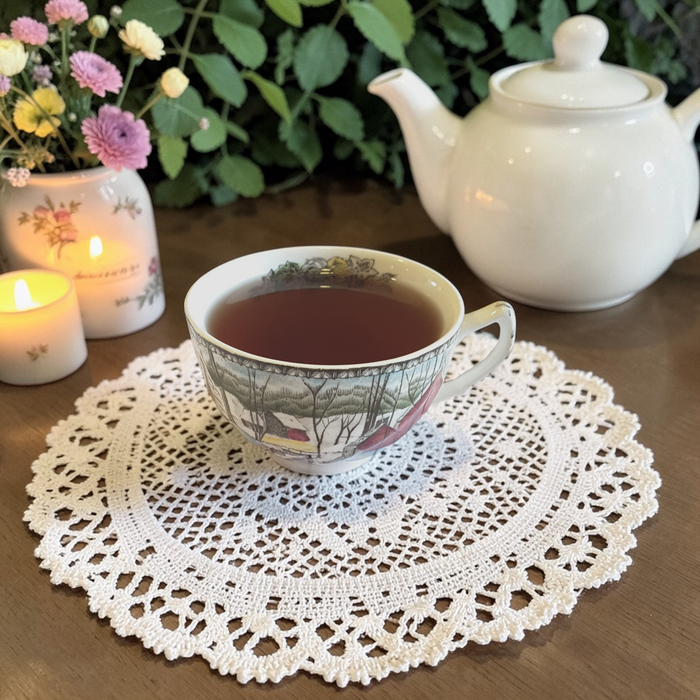 Immunity tea on a lace doily on a wooden surface with teapot and flowers in the background