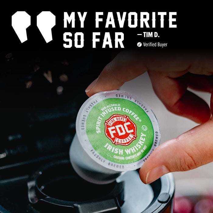 A hand inserts a FDC Spirit Infused Coffee K-Cup into a coffee maker. The top of the image features a quote graphic that reads 'MY FAVORITE SO FAR - TIM D.