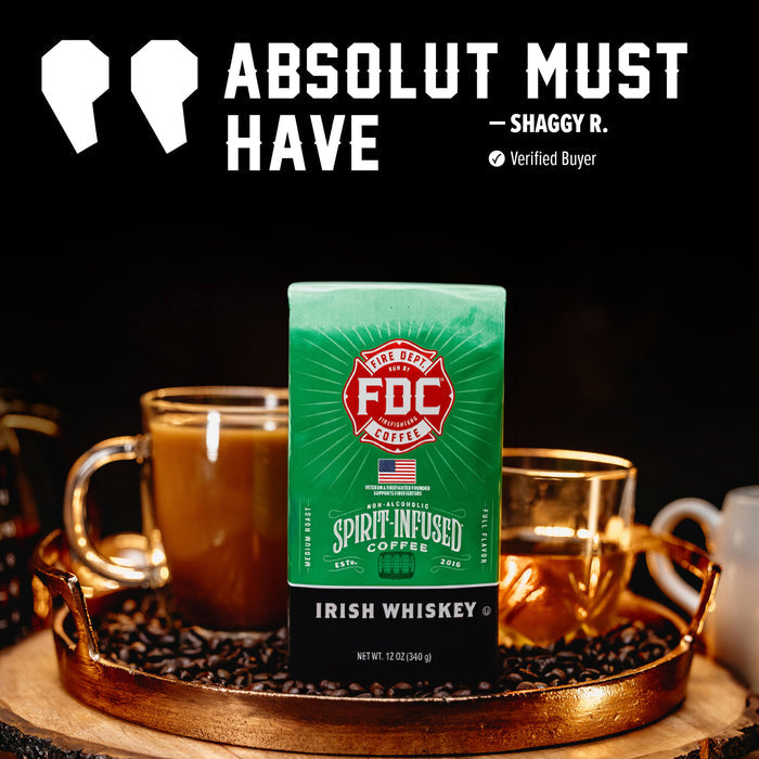 A green and black bag of FDC Spirit-Infused Coffee (Irish Whiskey flavor) is displayed on a wooden tray with coffee cups, set against a dark background with promotional text 'ABSOLUT MUST HAVE - SHAGGY R.'.