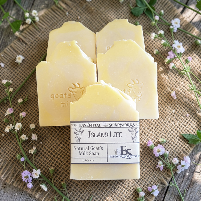 goat milk soap bars with a label on a rustic background with flowers