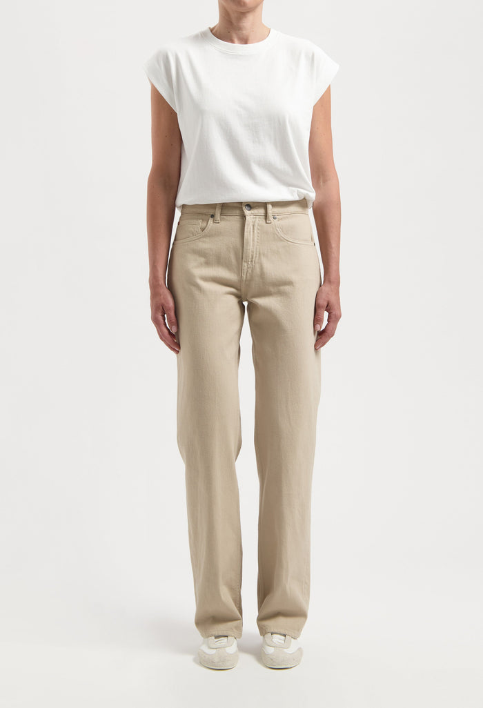 Casual beige straight-leg pants paired with a white short-sleeve top, highlighting relaxed fit and minimalist style.