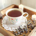 Joy emotional wellness tea on a wooden tray with dried lavender and candles