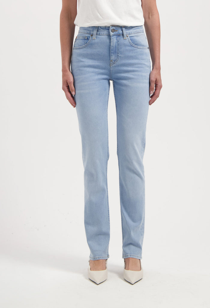 Light blue straight-cut denim jeans made from cotton, paired with an off-white top and white pointed-toe shoes.