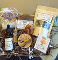 Mabon ritual kit filled with natural products including a bottle of Mabon essential oil, bath salts with flowers, a soap bar labeled Pumpkin Spice, a tea blend pouch, a red agate crystal, a mini besom, incense, and a candle, arranged in brown paper shred.