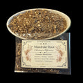Mandrake Root shown in a clear bowl filled with dried roots, with a clear packet of 10 grams in front displaying a cream label that reads 'Essential Soapworks Mandrake Root'.