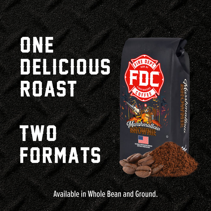 A bag of FDC Fire Department Coffee in the Marshmallawn Brownie flavor, shown next to a small pile of ground coffee and whole coffee beans on a dark textured background. Large white text on the left reads 'ONE DELICIOUS ROAST TWO FORMATS' with smaller text below stating 'Available in Whole Bean and Ground.