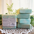 Mindful Presence Emotional Wellness Soap on a doily with plants in the background.