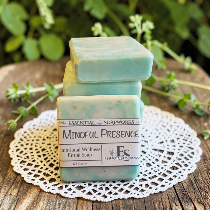 Mindful Presence Emotional Wellness Soap on a doily with plants in the background.