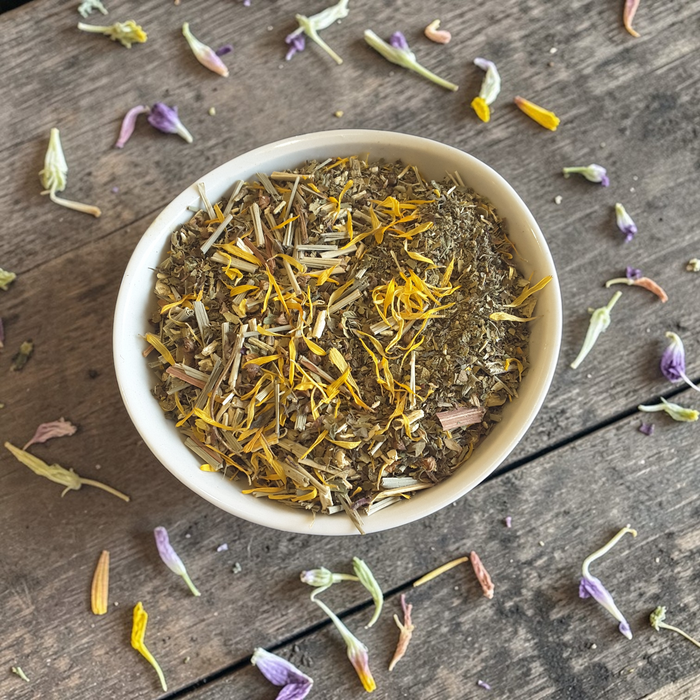 White bowl filled with yerba mate tea blend on a wooden surface