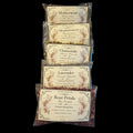 Five clear plastic bags of witchy herbs for peace and tranquility arranged in a vertical stack against a solid black background. The bags feature vintage-style cream labels with floral illustrations and text including 'Motherwort', 'Meadowsweet', 'Chamomile', 'Lavender', and 'Rose Petals'.