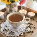 Restoration & Renewal Emotional Wellness Tea on a doily with candles and flowers in the background