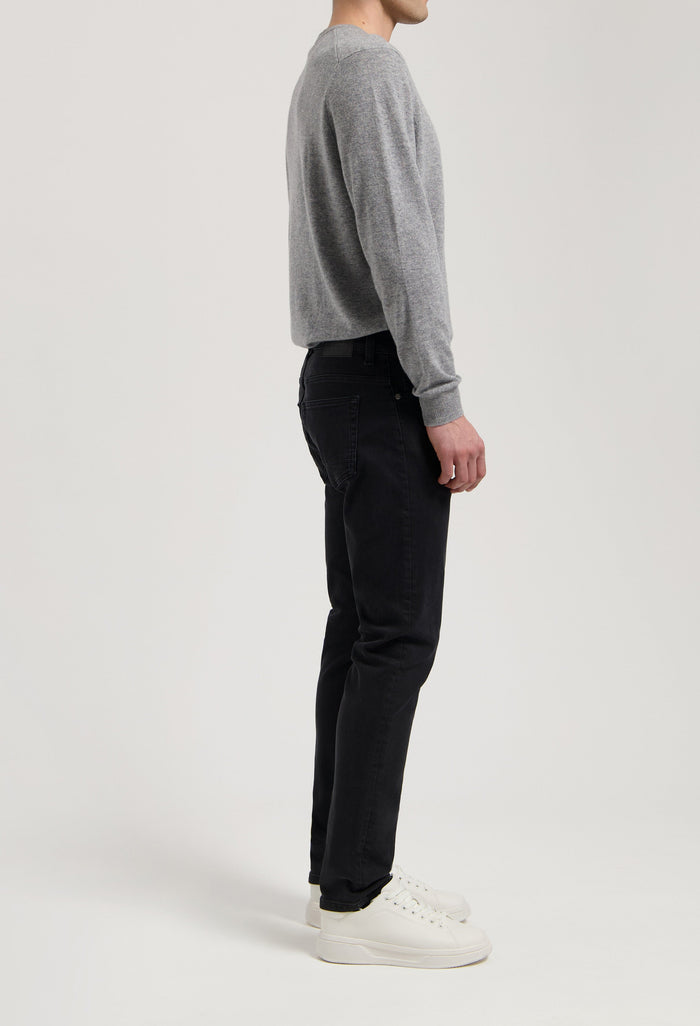 Sustainable MUD Jeans in deep blue denim, crafted ethically, styled with matching denim jacket, showcasing eco-friendly fashion.