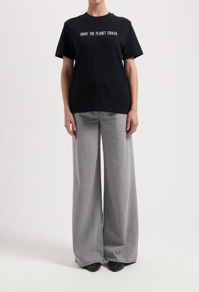 Sustainable MUD Jeans in dark brown, crafted with ethical materials, shown in a slim fit, paired with a casual white tee.