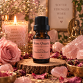 Rose Quartz witchy diffuser blend on a wooden surface with rose quartz crystals and roses with a candle in the background