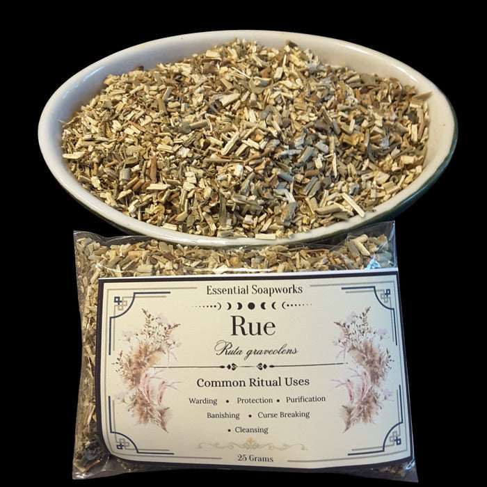 A bowl and bag of dried Rue (Ruta graveolens) botanicals for common ritual use, with the brand 'Essential Soapworks' visible on the label.