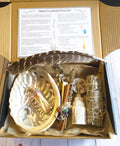 Smoke cleansing ritual kit featuring white sage smudge stick, abalone shell, selenite crystal tower, candle, and botanicals