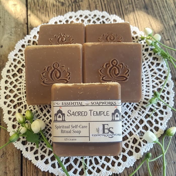 four bars of sacred temple soap on a doily on a wooden surface
