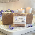 vanilla lavender serenity soap on a doily with purple flowers and candles in the background