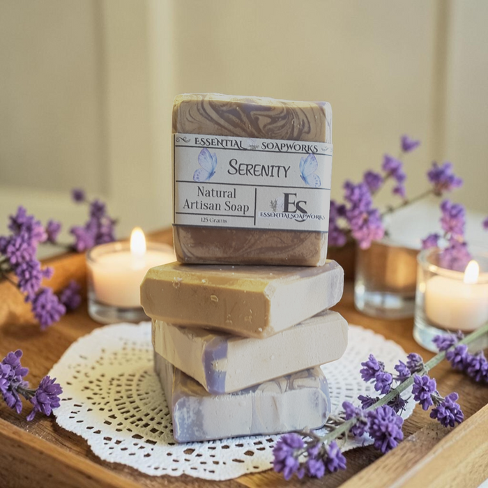 vanilla lavender serenity soap on a doily with purple flowers and candles in the background