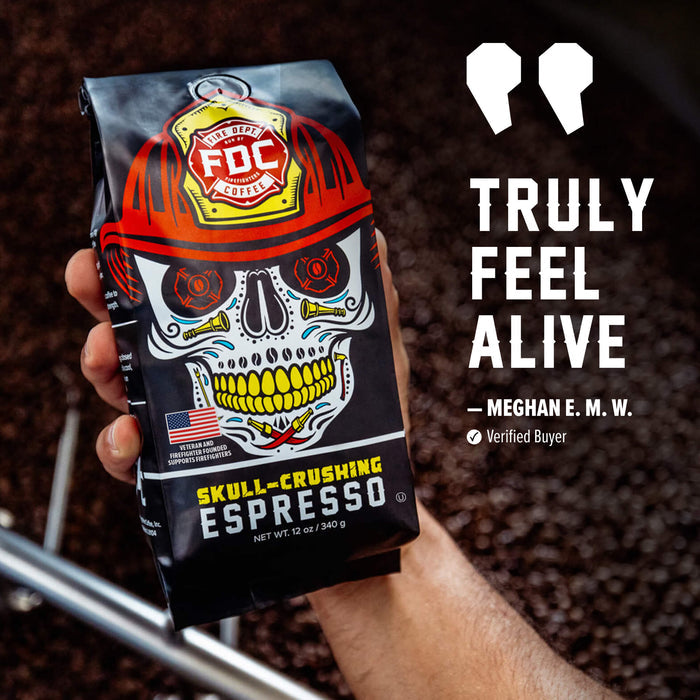 A hand holds a bag of FDC Coffee Roasted Espresso against a dark background of coffee beans. The bag features a graphic of a skull wearing a red hard hat with the FDC logo.