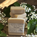 spiced woods tallow soap on a wooden surface with green leaves and white flowers