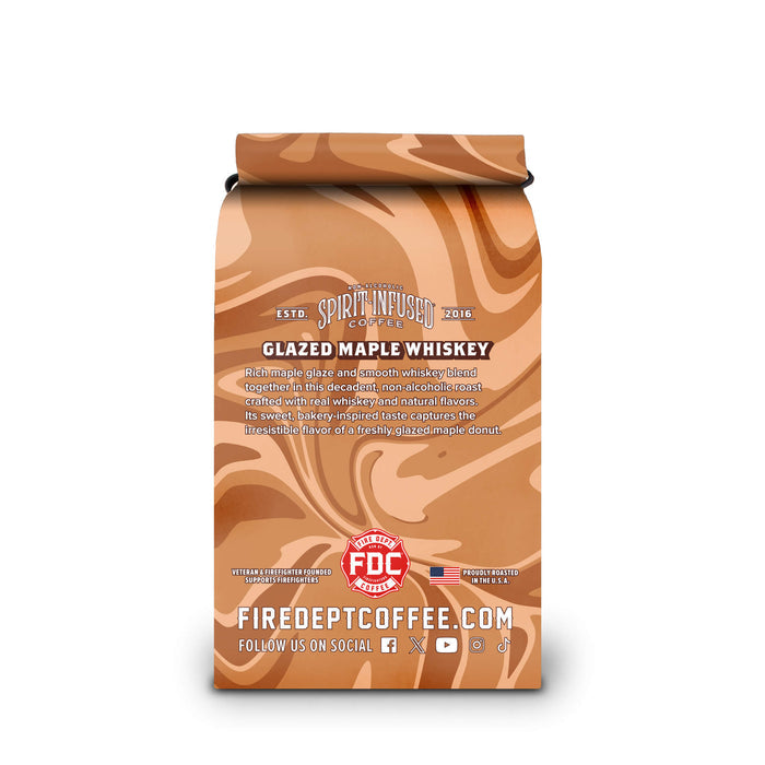 A coffee bag labeled 'Spirit Infused Coffee' with 'Glazed Maple Whiskey' flavor. The packaging features a glossy, swirling maple brown pattern in shades of orange, tan, and brown, with white text and a red FDC Certified logo near the bottom.