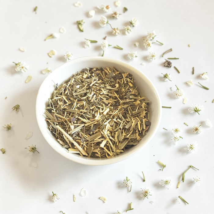 Steady Energy Emotional Wellness Tea on a light background with scattered herbs and flowers.