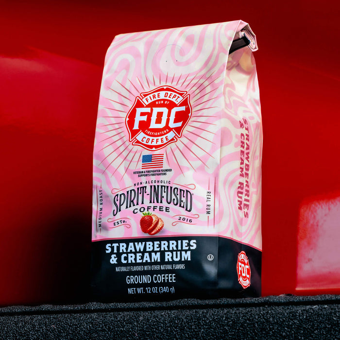 12oz bag of Strawberries and Cream Rum Infused Coffee on a dark red background.
