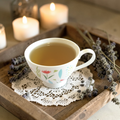 Strength & Boundaries Emotional Wellness Tea on a wooden tray with lavender and candles in the background