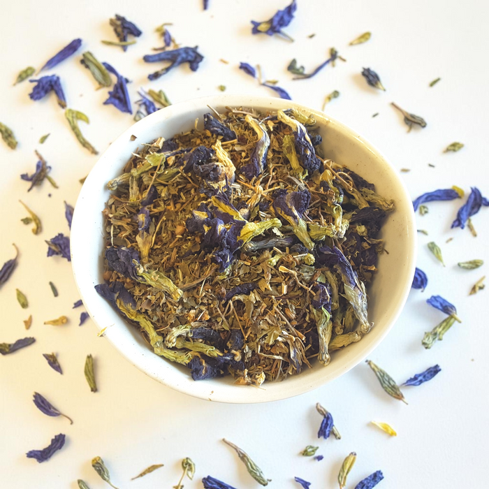 third eye loose leaf tea blend with butterfly pea flowers in a white bowl on a light background