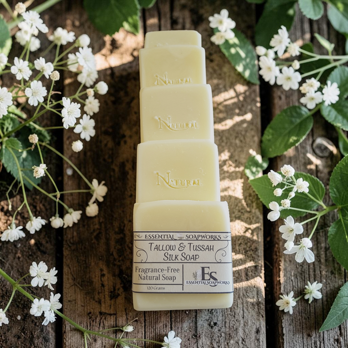 unscented tallow soap on a wooden surface with green leaves and white flowers
