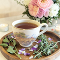Uplifting herbal tea with floral and herb arrangement on a wooden tray