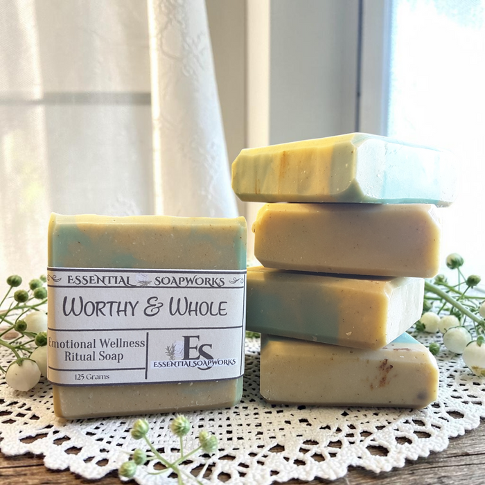 Worthy & Whole Emotional Wellness Soap on a wooden surface with decorative elements.