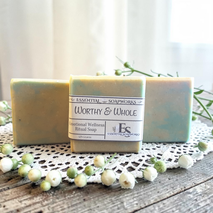 Worthy & Whole Emotional Wellness Soap on a wooden surface with decorative elements.